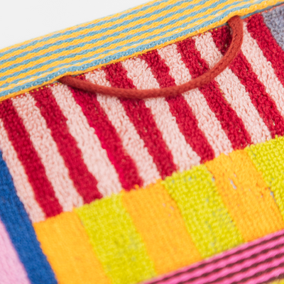 Colorful striped fabric with a pattern of red, yellow, blue, and pink.