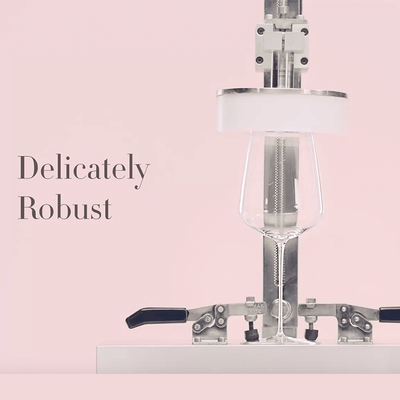 image depicting the strength of Stem Zero Wine Glasses, a robot is holding the glass thereby demonstrating the glasses strength against the very thin weight of the glass, it has a writing on the image: "delicately robost"