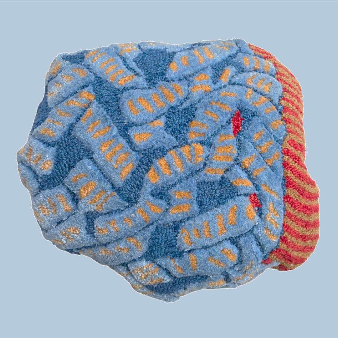 wool tufted cushion, red, blue and yellow coloured abstract motif of a snake, designed by Trine Krüger of Haus Üger