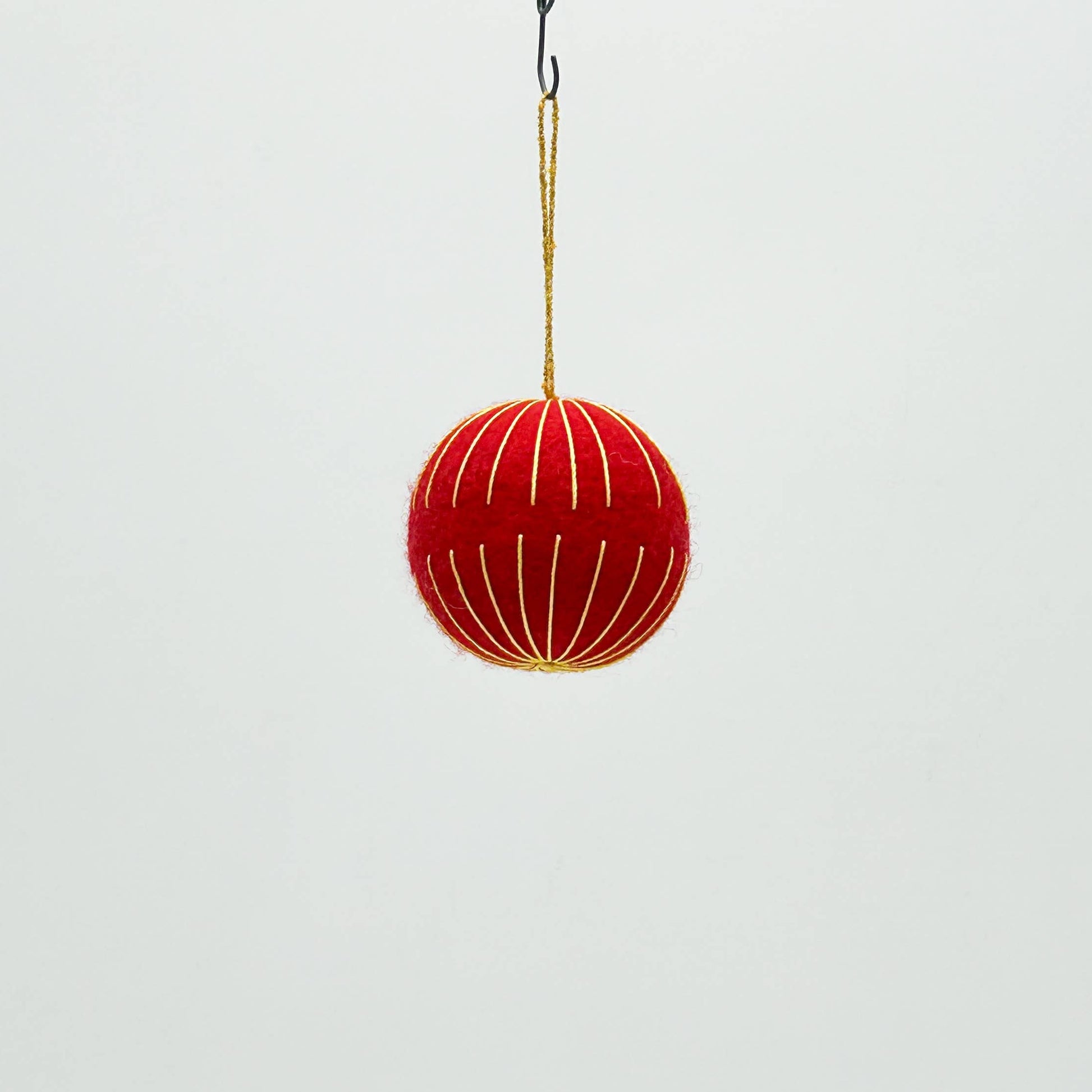 Red decorative ball hanging on a white background
