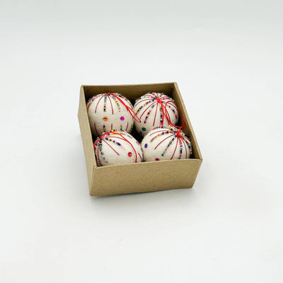 Box of wool felted decorative christmas balls, with sequinse and embroidery on a white background