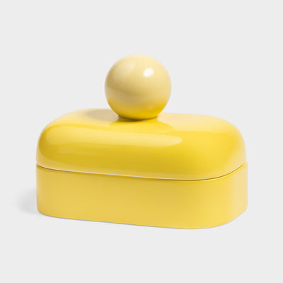 a bright yellow small storage jar with a spherical handle on top, on a white background
