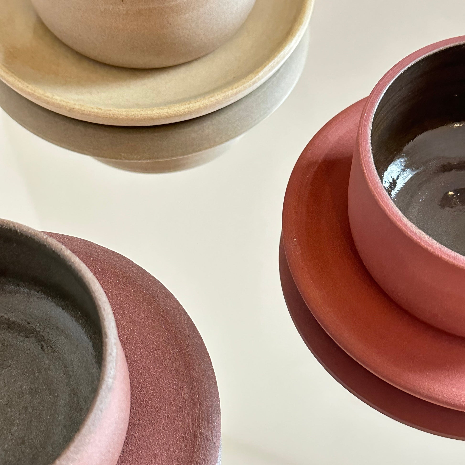 Three ceramic bowls in different colors on a light background