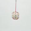 Decorative spherical ornament with colorful beads hanging on a red string against a light gray background
