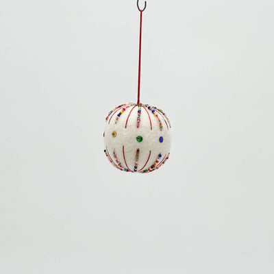 Decorative spherical ornament with colorful beads hanging on a red string against a light gray background