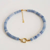 Blue beaded necklace with gold clasp on a white background
