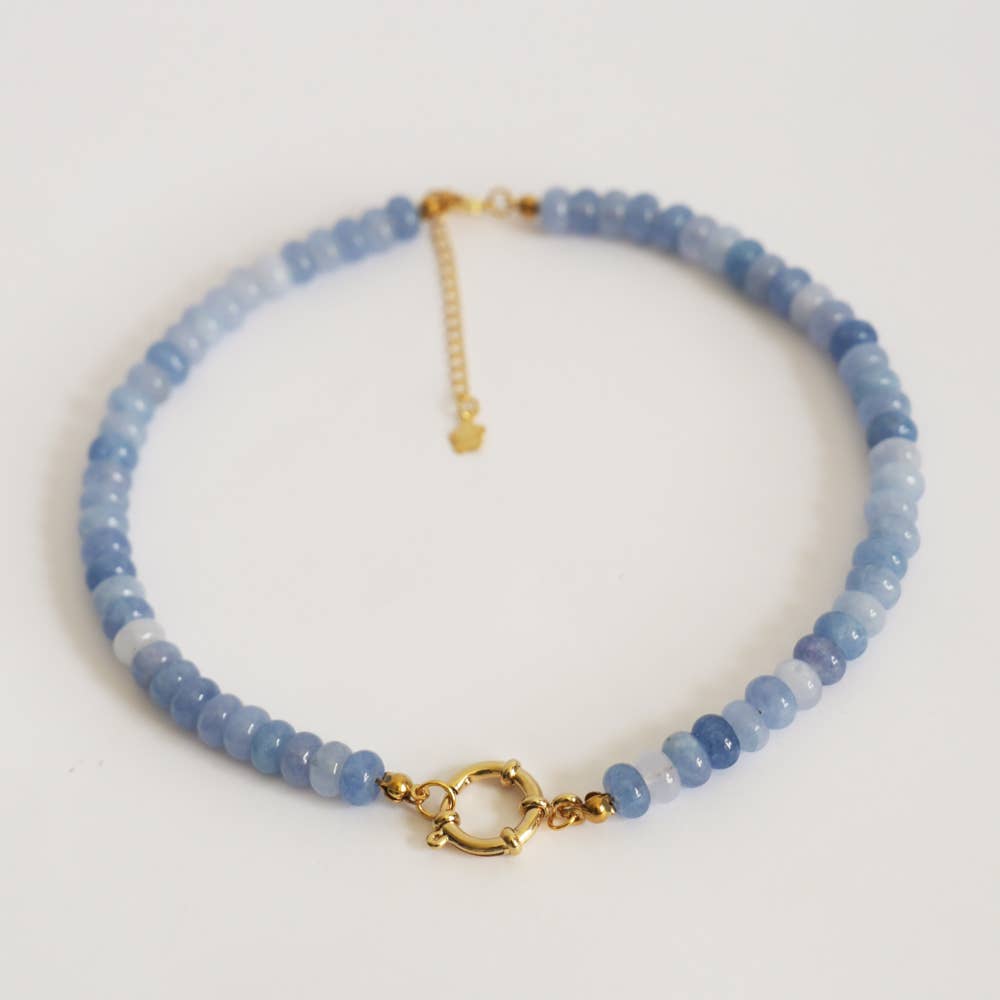 Blue beaded necklace with gold clasp on a white background