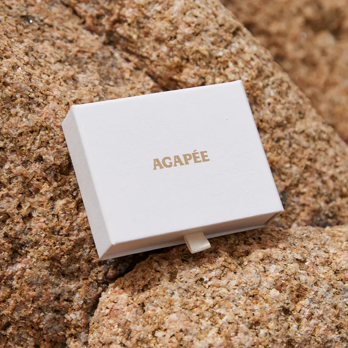 White box with 'AGAPèE' branding on a textured brown surface
