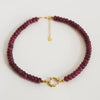 Beaded necklace with gold clasp on a light gray background
