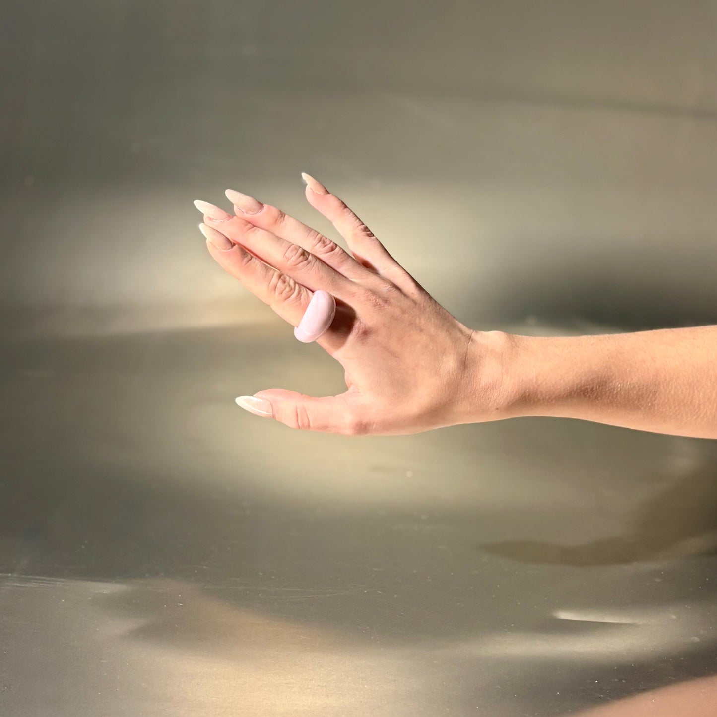 Hand with a ring on a reflective surface