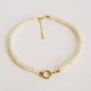 beaded necklace with gold clasp on a light gray background