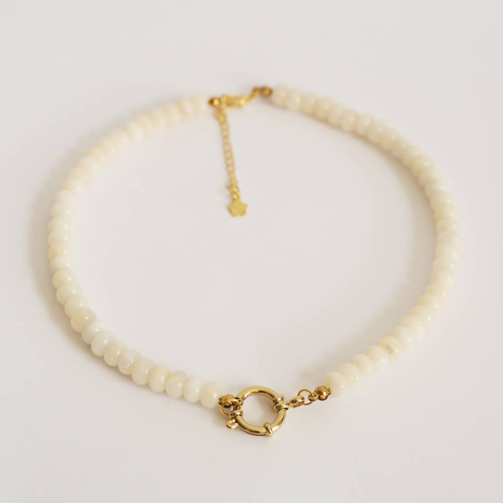 beaded necklace with gold clasp on a light gray background