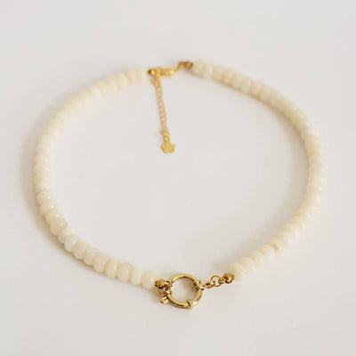 beaded necklace with gold clasp on a light gray background