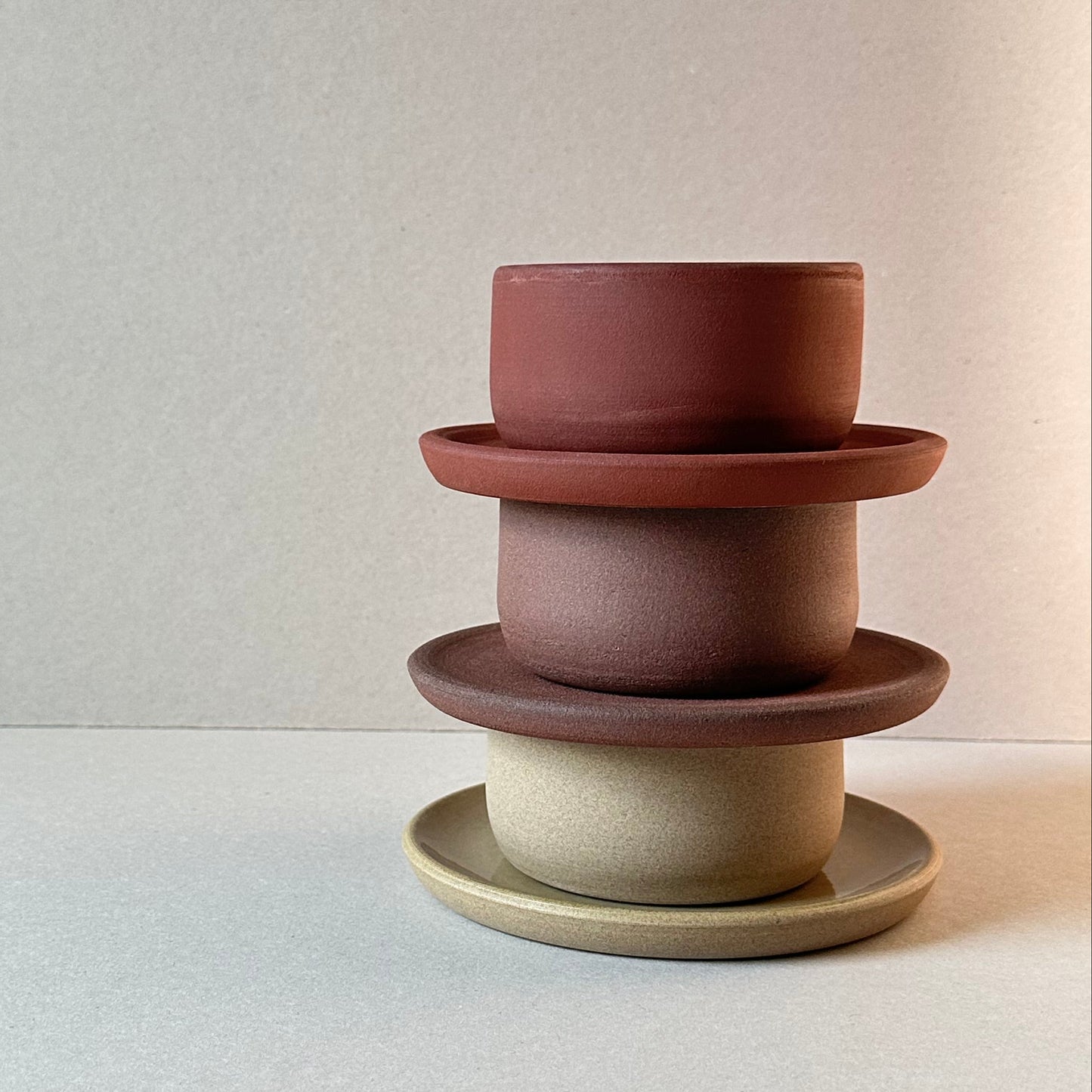 Two ceramic knobs in brown and beige on a light gray background