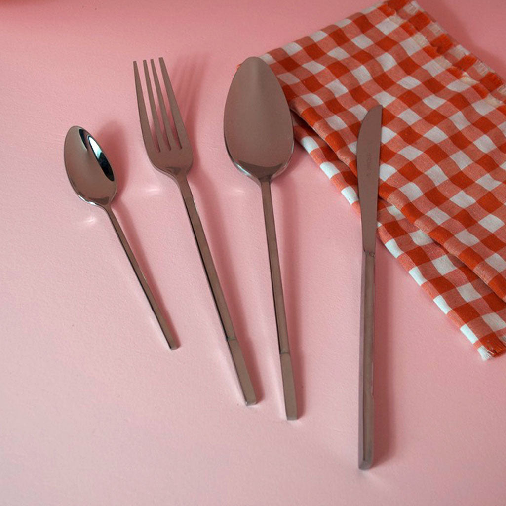 Stainless Steel Cutlery Set "Allegro" by Hedmar, on a pink table with a gingham napkin, 16 piece set made in portugal