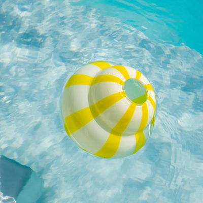 Yellow and white striped vase floating in clear blue water.
