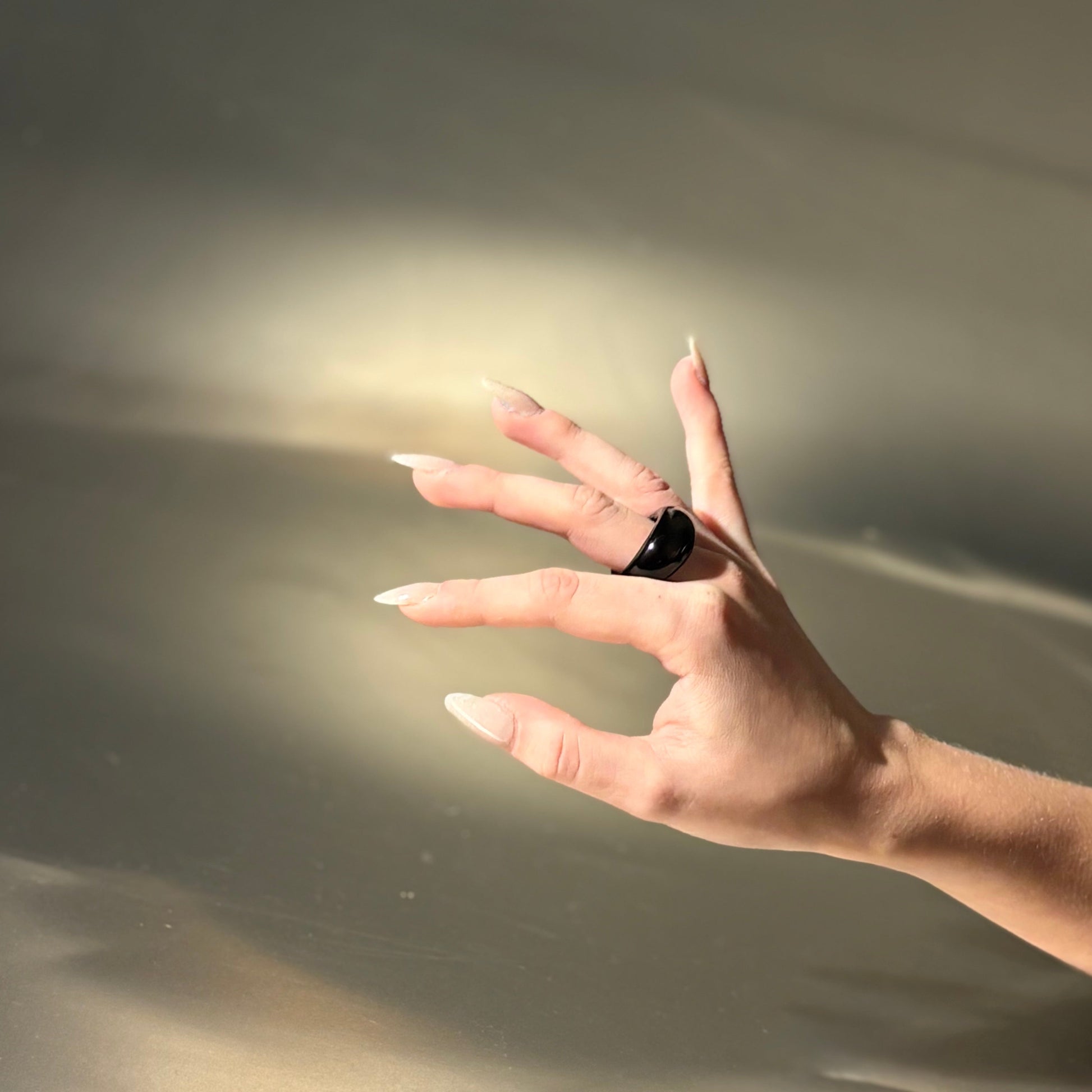 Hand with a ring on a textured surface