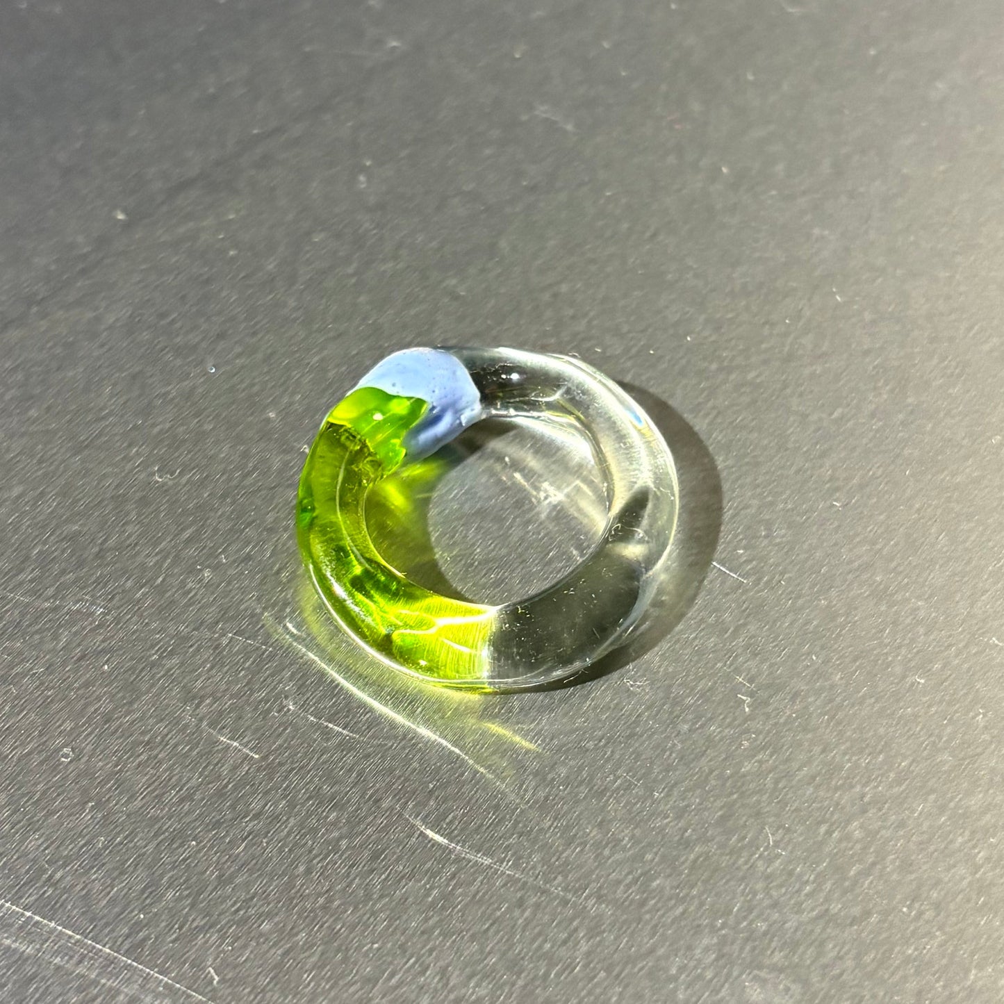 glass ring with a green streak on a gray surface