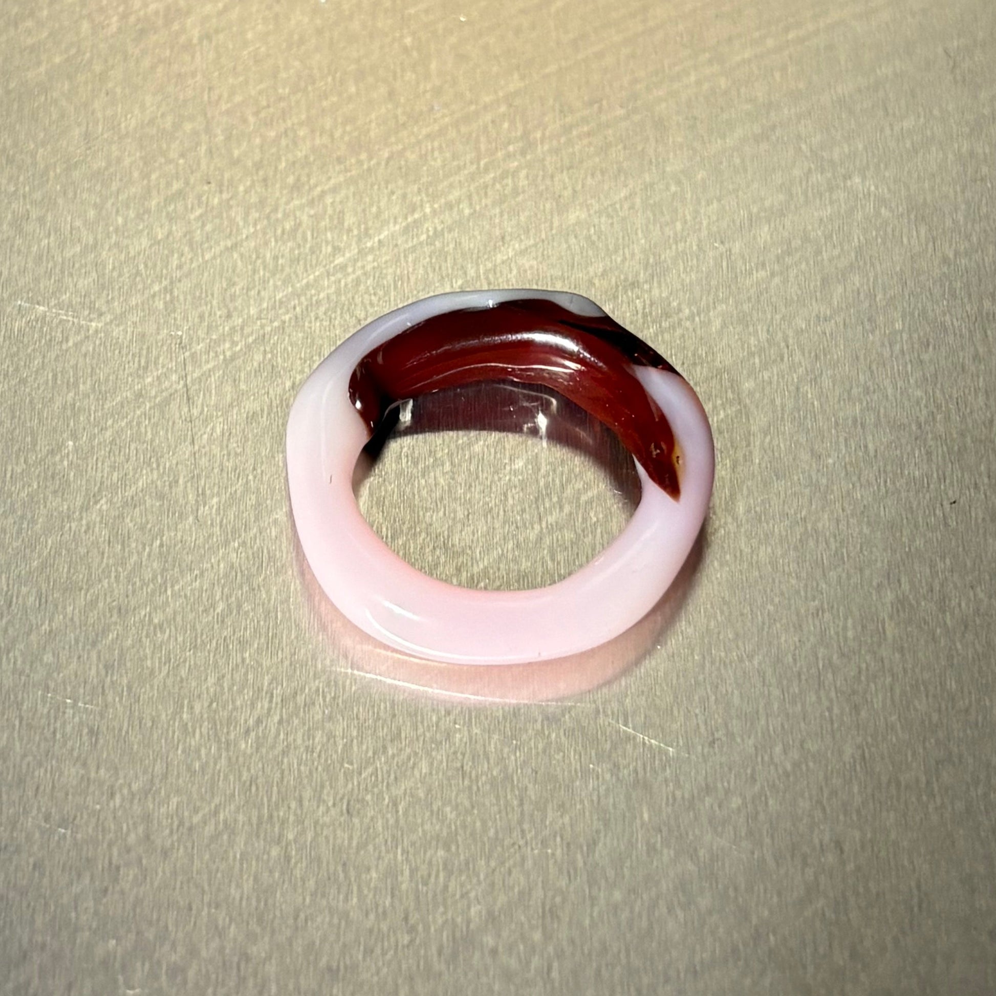 Two-tone ring with pink and brown on a beige background
