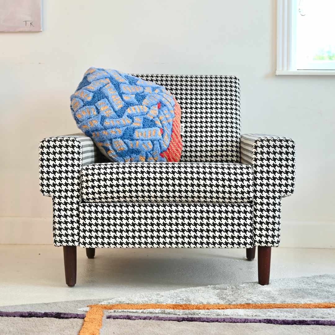 wool tufted cushion "medusa" on a black and white houndstooth covered armchair