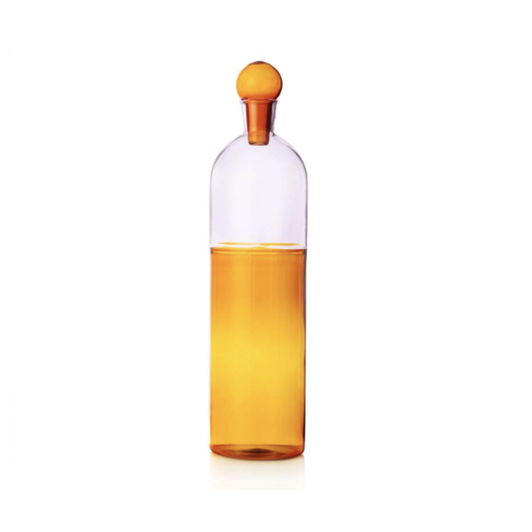 amber & pink glass water bottle with a glass stopper, on a white background