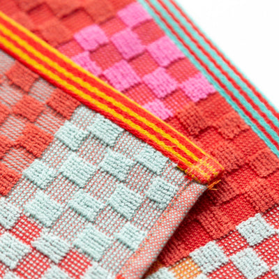 close up of wild weave kitchen cloth with a striped edge, bright colours in red, mint, turquoise and pink