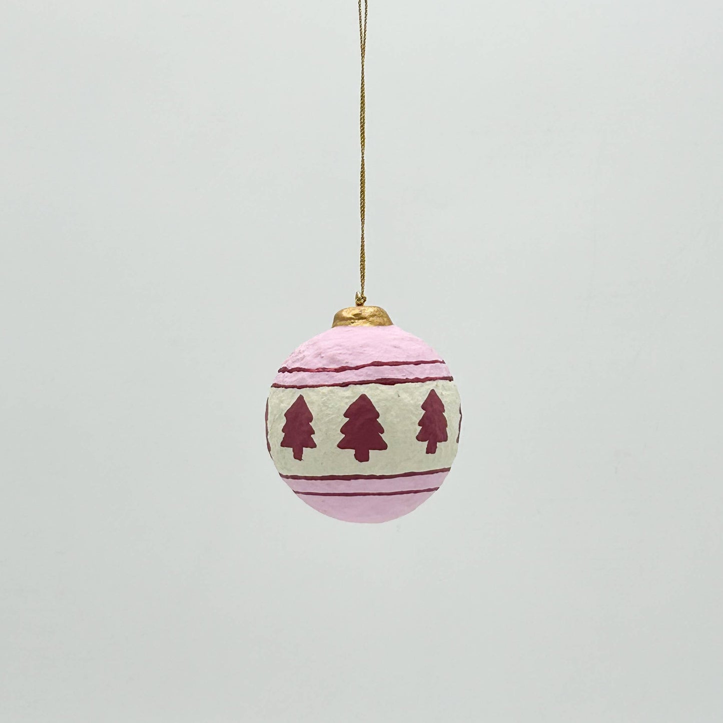 Decorative Christmas ball ornament with tree pattern on a light gray background