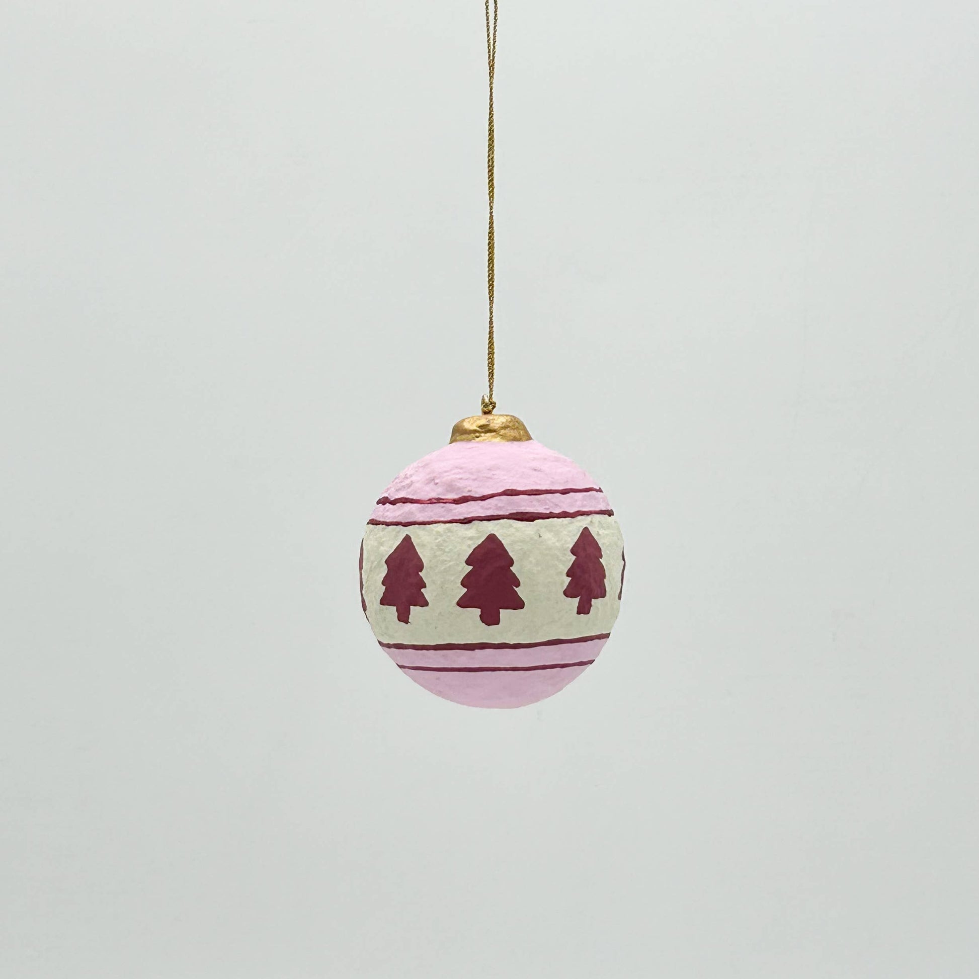 Decorative Christmas ball ornament with tree pattern on a light gray background