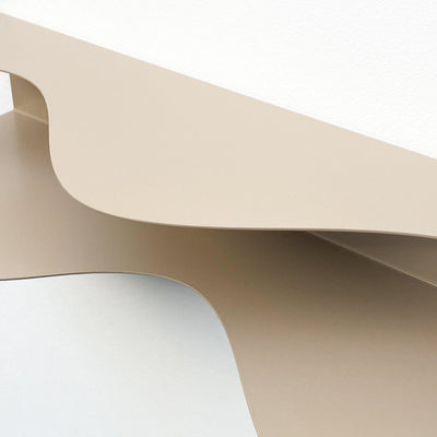 detail of blob shaped curvy shelf in beige against a white wall