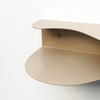 detail of blob shaped curvy shelf in beige against a white wall