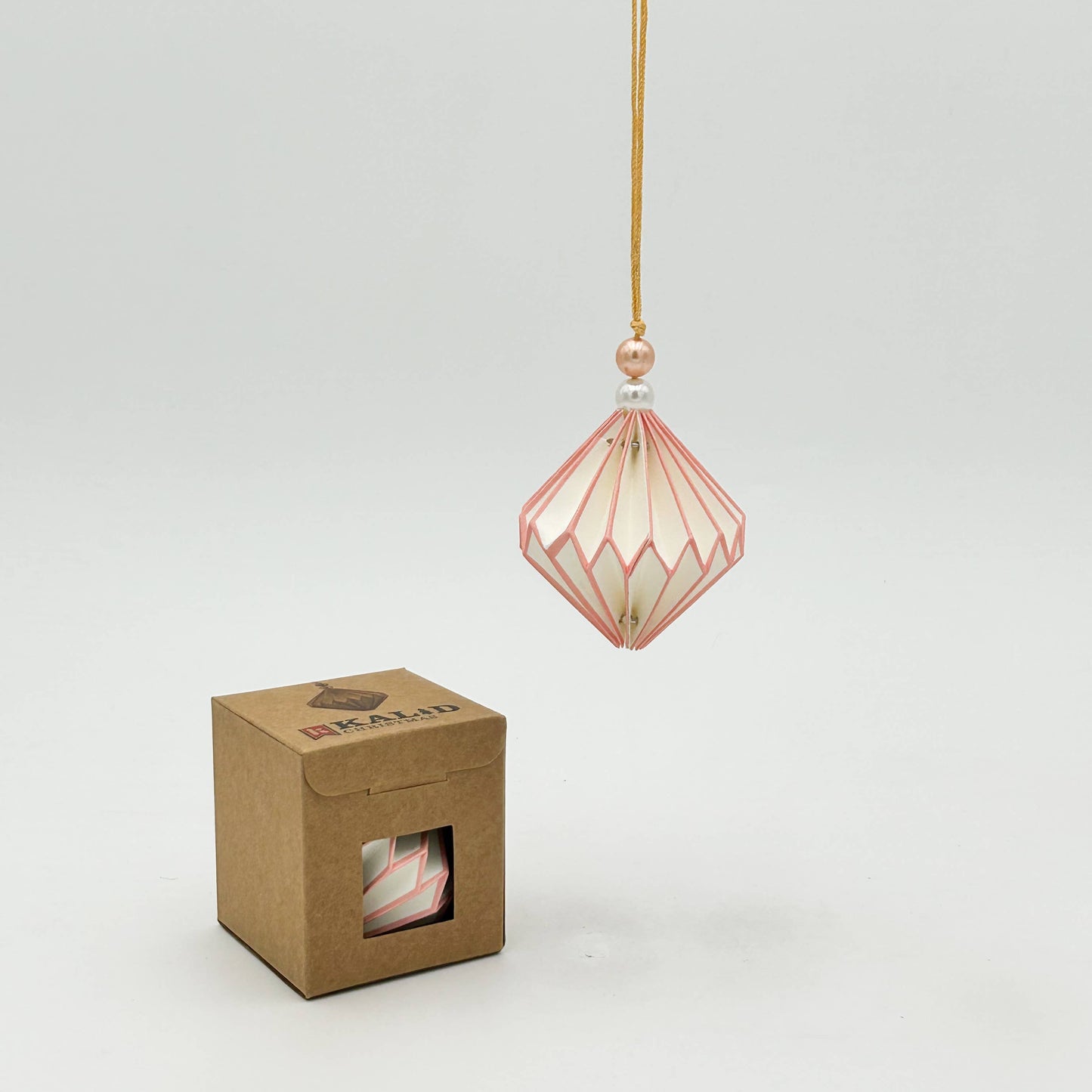 Decorative hanging lantern with a cardboard box on a light gray background