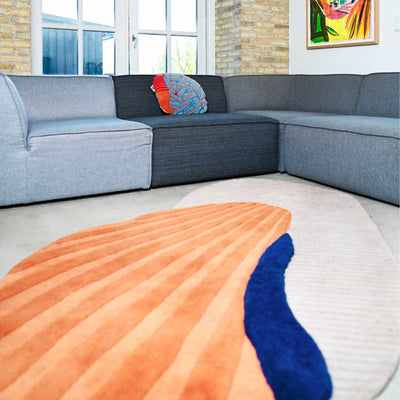 Layer Wool Carpet by Trine Krüger | Cream Base with Off-Centered Oyster Shell Structure | Striking Orange and Blue Contrast | Elongated Shape with 3-Dimensional Stripe Effect | Limited Edition Exclusive Design by Haus Üger
