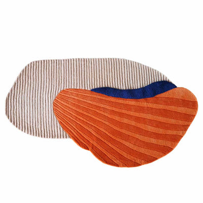 Layer Wool Carpet by Trine Krüger | Cream Base with Off-Centered Oyster Shell Structure | Striking Orange and Blue Contrast | Elongated Shape with 3-Dimensional Stripe Effect | Limited Edition Exclusive Design by Haus Üger