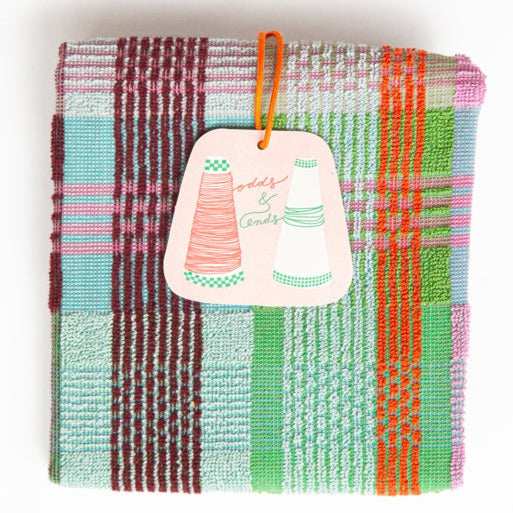 wild weave kitchen towel #11, by foekje fleur, folded terry kitchen towel in bright colours green, pink, blue and burgundy, photographed on a white background with hangtag