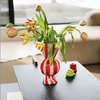 red and white striped vase with tulips on a black coffee table