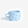 Light blue ceramic mug with textured surface on a white background