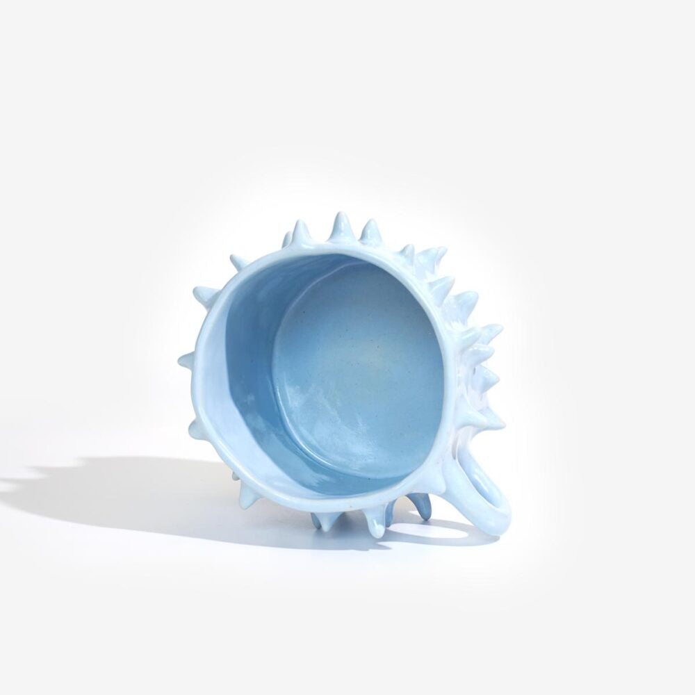 Light blue ceramic bowl with spiky rim on a white background
